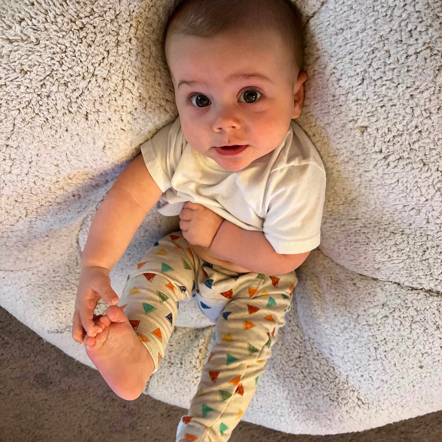 Reece is registered to the contest to win money with this photo: baby, baby_toddler_clothing, beauty, cheek, child, comfort, eye, face, finger, flooring, human, human_body, iris, pattern, sitting, skin, sleeve, textile, toddler, wood