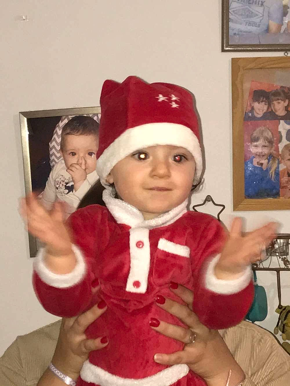 Gabrielle participe au concours pour gagner de l'argent avec cette photo : baby, cap, child, christmas, christmas_eve, event, fictional_character, fur, gesture, glove, hand, happy, headwear, holiday, joy, lap, person, picture_frame, santa_claus, sleeve