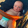 baby, blue_eyes, diaper, stroller, leather_handle, sunlight, child, infant, outdoor, skin, face, legs, hand, seat, black_stroller, young_child, serious_expression, summer, daylight, closeup
