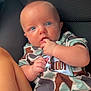 baby, infant, child, onesie, camouflage, blue_eyes, fingers, cute, sitting, car_seat, legs, skin, expression, clothing, person, portrait, indoor, comfort, young, closeup