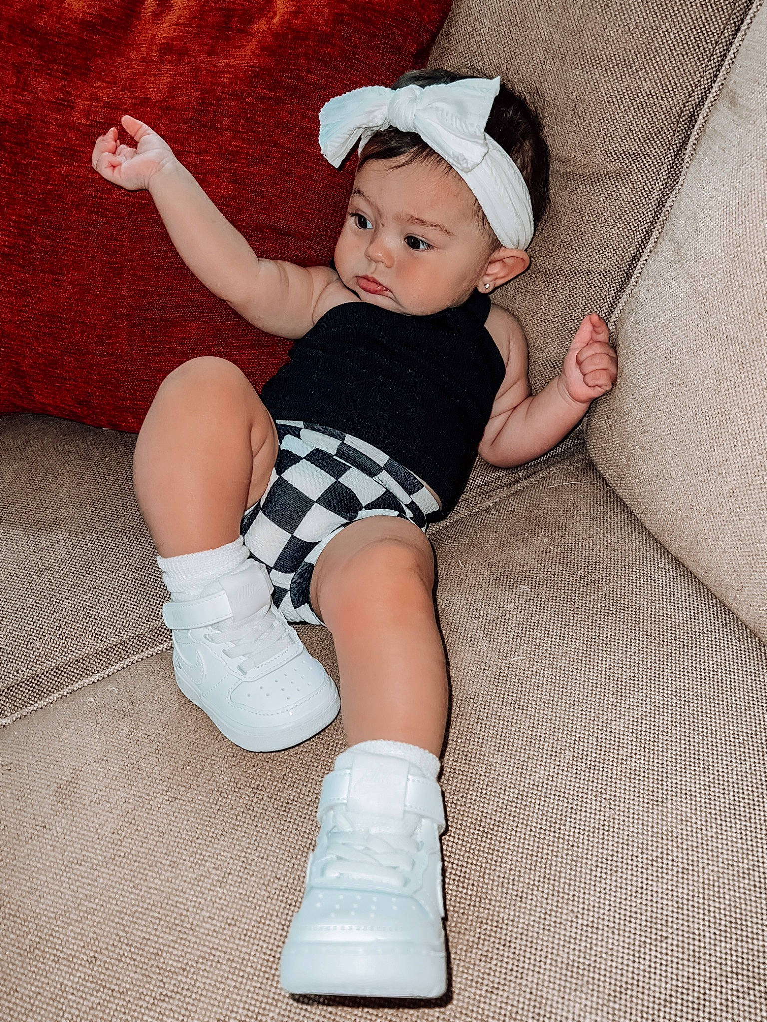 Blakely is registered to the contest to win money with this photo: baby, baby_toddler_clothing, cap, comfort, face, finger, foot, headwear, human_body, human_leg, knee, lap, leg, pattern, person, shoe, sitting, sleeve, sock, thigh