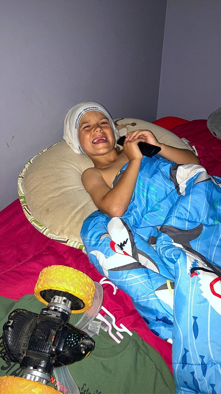 Karson joined the competition — help win amazing prizes! carmine, child, comfort, elbow, electric_blue, event, fun, glove, headwear, joy, leisure, linens, person, personal_protective_equipment, recreation, room, sitting, smile, t_shirt