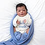 Lucas is registered to the contest to win money with this photo: newborn, baby, infant, swaddle, blanket, blue_blanket, onesie, booties, portrait, face, hands, dark_hair, bed, white_sheet, cozy, cute, newborn_photography, soft_light, tiny_fingers, hello_world_text