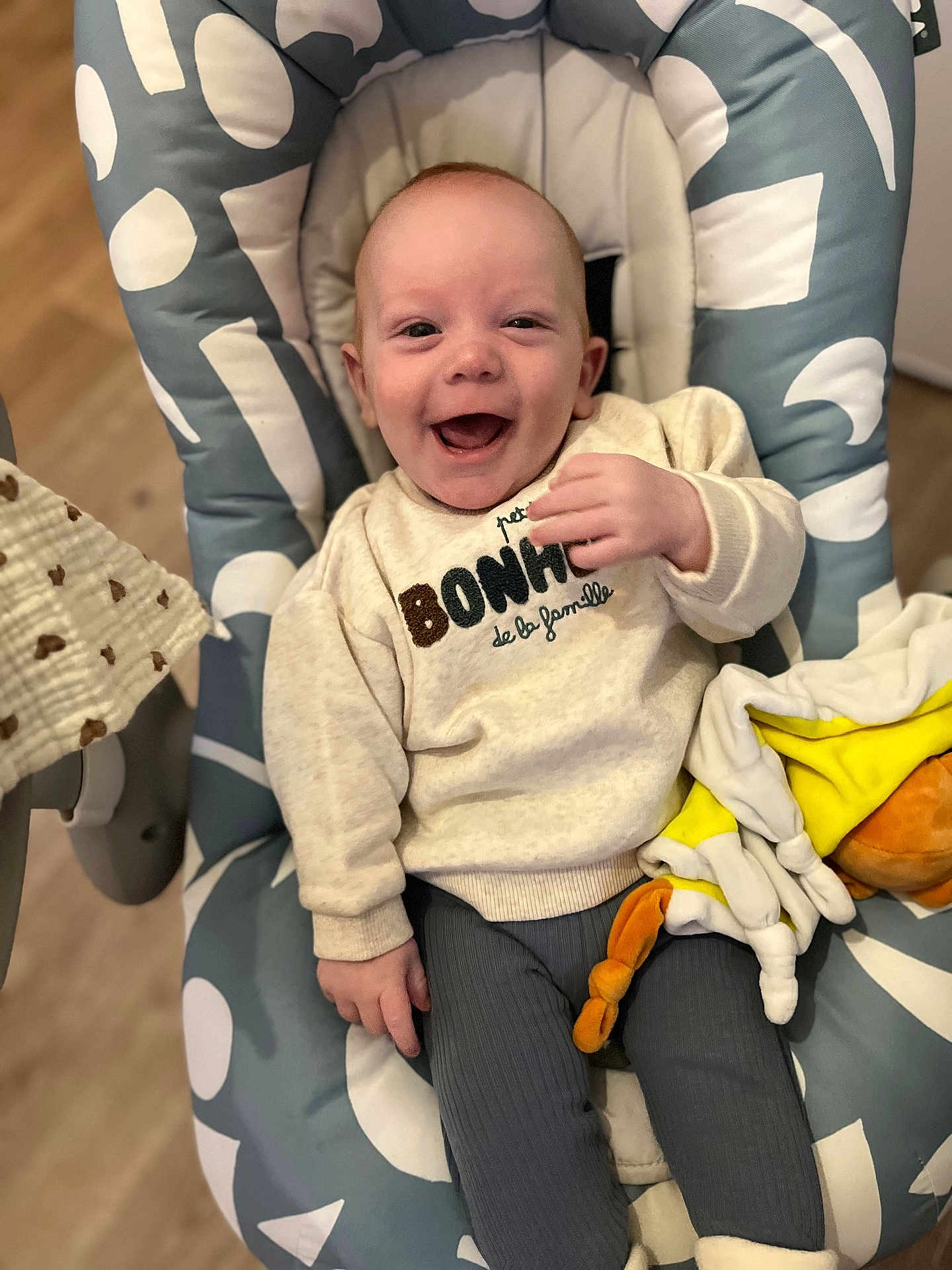 Elio a rejoint le concours — aidez-le/la à gagner de superbes lots ! baby, smiling, child, sweater, plush_toy, baby_chair, happy, indoor, portrait, clothing, person, infant, cute, seated, cozy, fabric, soft_toy, floor, expression, young_child