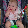 Maez is registered to the contest to win money with this photo: baby, child, infant, stroller, smiling, happy, outdoor, portrait, sitting, fingers, bib, pink_clothing, white_clothing, toy, bee_toy, baby_bottle, safety_harness, colorful, playground, daylight