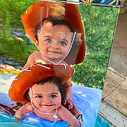 Joel-Jerimiah is registered to the contest to win money with this photo: baby, cowboy_hat, child, smile, outdoor, grass, blue_blanket, boots, cute, stacked, portrait, two_children, playful, hat_string, bare_chest, happy, infant, sunlight, person, fun