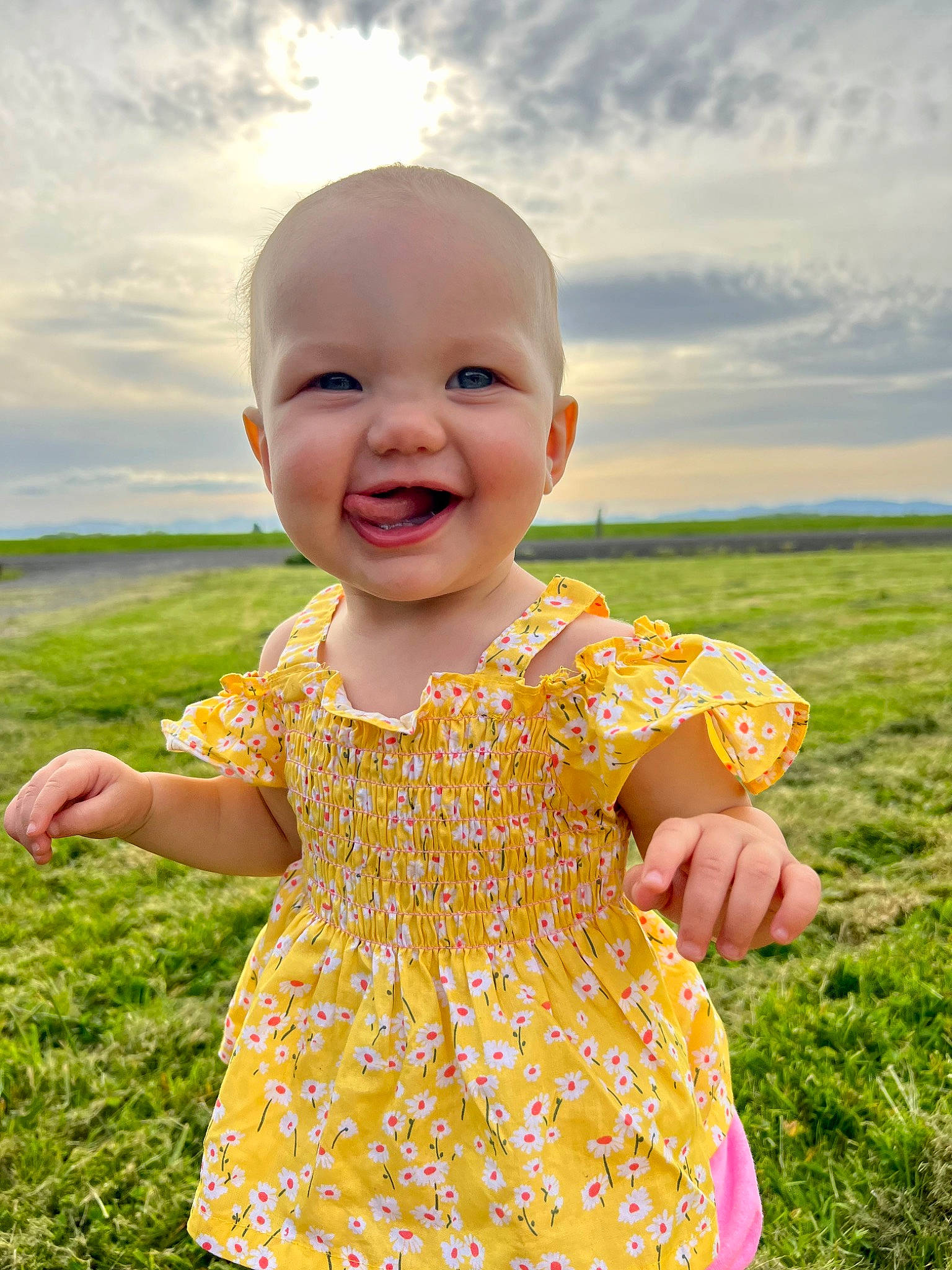 Huntleigh is registered to the contest to win money with this photo: baby_toddler_clothing, child, clothing, cloud, dress, facial_expression, gesture, grass, happy, joy, nature, one_piece_garment, people_in_nature, person, pink, plant, skin, sky, sleeve, smile