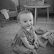 Amara a rejoint le concours — aidez-le/la à gagner de superbes lots ! baby, child, infant, sitting, carpet, toy, pigtails, smiling, indoor, furniture, wicker_chair, table, basket, plant, dress, barefoot, cushion, floor, portrait, homedecor
