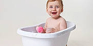 Millie is registered to the contest to win money with this photo: toddler, child, bathtub, bath, bubbles, pink_sponge, rubber_duck, toy, white_tub, clawfoot_tub, smiling, happy, baby, bath_time, clean_background, studio_shot, indoor, cute, playful, water