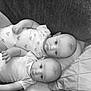 baby, black_and_white, child, closeup, cozy, cute, face, heart_pattern, indoor, infant, lying_down, monochrome, newborn, onesie, person, pillow, portrait, soft_texture, toddler, two_babies