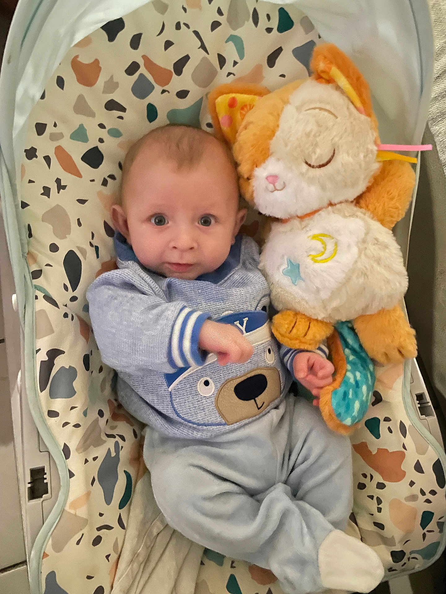 Tiago Mary participe au concours pour gagner de l'argent avec cette photo : baby, baby_seat, bear_design, blue_outfit, child, comfort, cozy, cute, expression, footwear, hand, indoor, infant, patterned_seat, plush_toy, sleepy_cat, soft_lighting, stuffed_animal, toy, wide_eyes