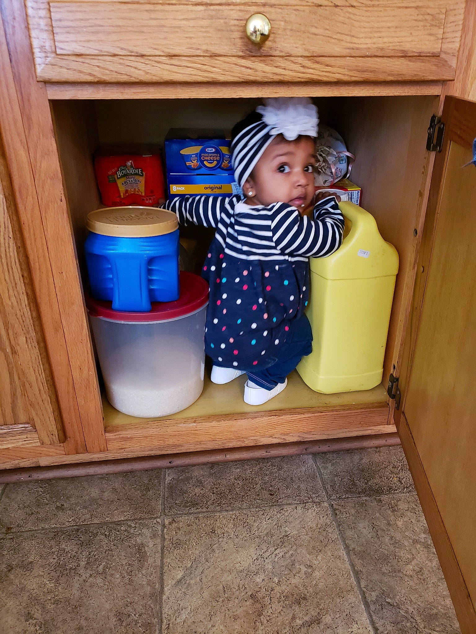 Mia is registered to the contest to win money with this photo: child, cupboard, furniture, headwear, person, play, room, shelf, surprise, toddler, wood