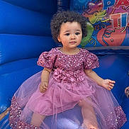 Alyza joined the competition — help win amazing prizes! toddler, child, curly_hair, pink_dress, sequin, inflatable, bounce_house, blue, sitting, barefoot, flower_belt, indoor, portrait, cute, young_child, play_area, colorful, fun, event, party