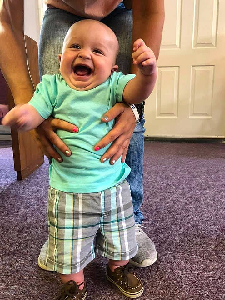 Hank is registered to the contest to win money with this photo: baby, baby_toddler_clothing, child, door, event, fun, gesture, grass, happy, hat, leisure, pattern, person, plaid, sleeve, smile, standing, t_shirt, tartan, thumb