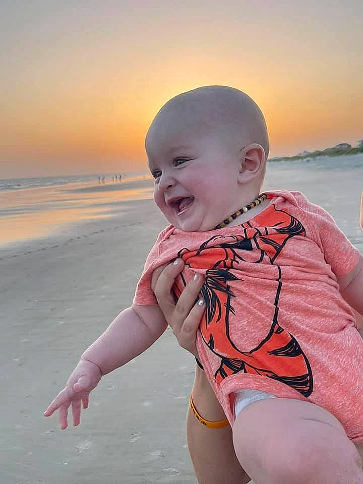 Hank is registered to the contest to win money with this photo: baby, baby_toddler_clothing, beach, beauty, face, flash_photography, fun, happy, leisure, morning, people_in_nature, people_on_beach, person, pink, skin, sky, smile, swimwear, thigh, toddler