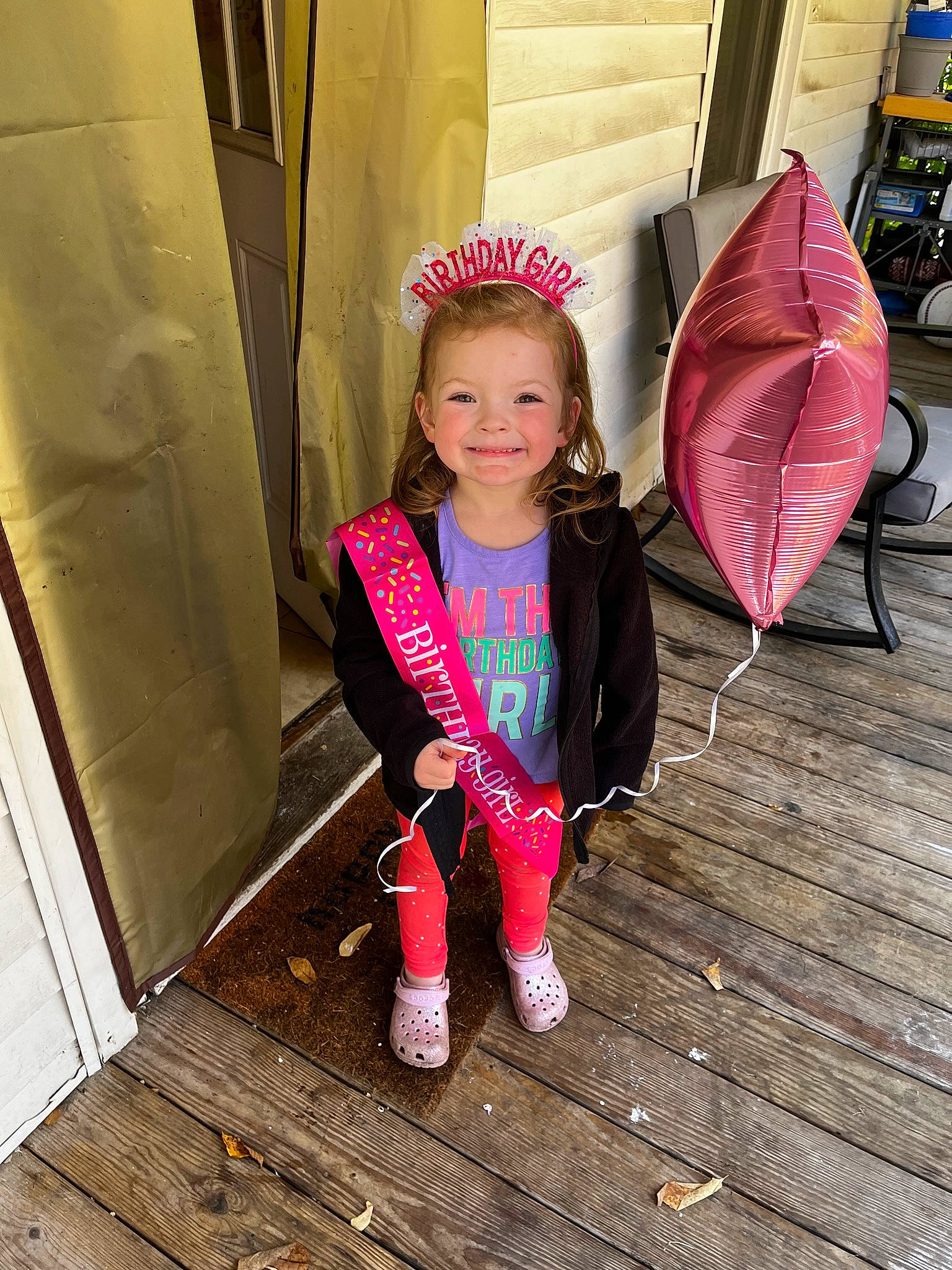 Mila is registered to the contest to win money with this photo: child, cool, costume, door, fashion_accessory, flooring, fun, happy, human_leg, joy, leisure, magenta, person, personal_protective_equipment, pink, sitting, thigh, toddler, umbrella, vacation