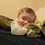 baby, blanket, bed, child, cozy, cute, face, happy, indoors, infant, laying_down, person, portrait, resting, sleepy, soft, smile, toddler, warm, young