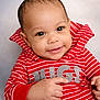 baby, infant, smile, portrait, red_striped_shirt, clothing, hand, eye_contact, close_up, soft_background, cute, adorable, cheeks, head, face, skin, sleeve, young_child, studio_photo, happy