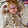 baby, smiling, head_wrap, floral_outfit, blanket, lying_down, happy, infant, cute, child, pattern, soft_texture, raised_arms, portrait, buttoned_clothing, indoors, light, skin, face, expression