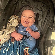 Casen joined the competition — help win amazing prizes! baby, blanket, blue_shirt, child, clothing, comfort, cute, expression, face, hands, happy, indoor, infant, person, portrait, relaxation, seat, smiling, stroller, young_child