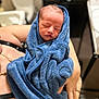 newborn, baby, blue_towel, wrapped, sleeping, infant, person, arms, skin, soft, peaceful, closeup, indoor, human, gentle, care, portrait, blanket, rest, toddler