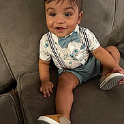 Elijah Daniel joined the competition — help win amazing prizes! toddler, child, smiling, sitting, couch, shoe, bow_tie, suspenders, shorts, shirt, happy, indoors, baby, portrait, cute, clothing, footwear, furniture, person, face