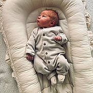Lowen participe au concours pour gagner de l'argent avec cette photo : newborn, baby, onesie, baby_lounger, soft_texture, neutral_colors, infant, sleepwear, cushion, cozy, curious, indoor, carpet, small_hands, footwear, sleeping_area, calm, child, portrait, resting