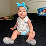 Genesis joined the competition — help win amazing prizes! baby, child, blue_headband, sparkly_shoes, bed, black_bedspread, indoor, person, curious, sitting, clothing, shorts, shirt, headwear, footwear, furniture, blurred_background, home, portrait, expression