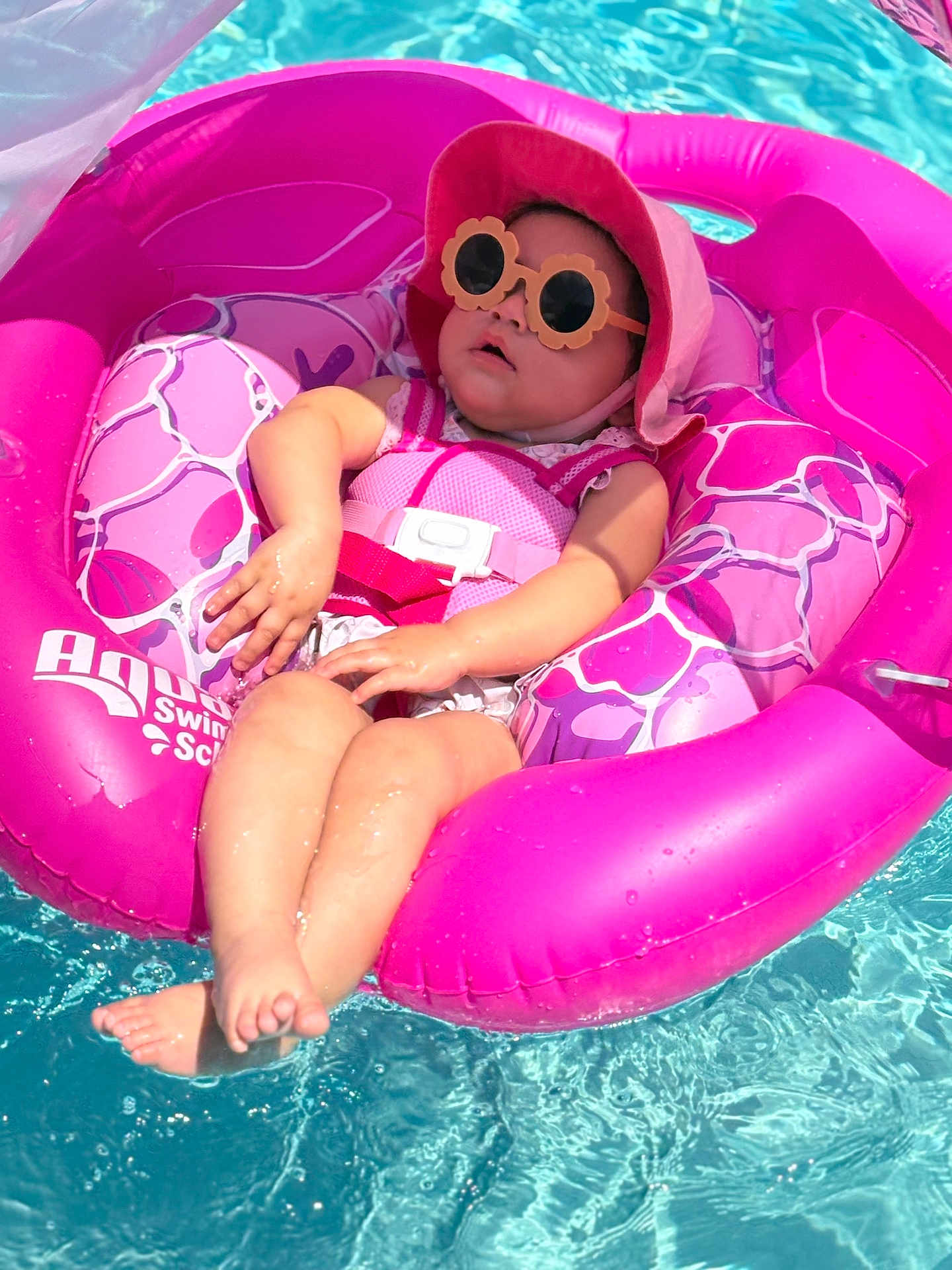 Genesis is registered to the contest to win money with this photo: baby, floatie, pool, water, sunglasses, hat, pink, child, sunhat, summer, swimming, relaxing, outdoor, infant, safetyvest, cute, sunny, vacation, fun, leisure