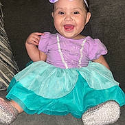 Genesis is registered to the contest to win money with this photo: baby, child, smiling, dress, headband, starfish, purple, teal, couch, happy, sitting, footwear, indoor, cute, person, portrait, clothing, toddler, accessory, home