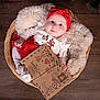 baby, infant, basket, red_headband, white_clothing, holiday, christmas, envelope, letter, wooden_floor, fluffy_blanket, cute, festive, child, lying_down, portrait, holiday_decoration, cozy, toddler, gift