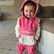 Elysa a rejoint le concours — aidez-le/la à gagner de superbes lots ! toddler, child, smiling, hoodie, pink_clothing, indoor, living_room, tile_floor, shoes, casual, person, young_child, cute, portrait, standing, hands_in_pockets, cozy, happy, home, fashion