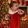 Elysa a rejoint le concours — aidez-le/la à gagner de superbes lots ! toddler, child, red_dress, lace, christmas_tree, fireplace, stockings, holiday, festive, toy, string, carpet, presents, decorations, smiling, indoor, cute, celebration, happy, person