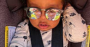 Emaan joined the competition — help win amazing prizes! baby, child, infant, car_seat, sunglasses, portrait, sitting, harness, buckled, curly_hair, onesie, blanket, fashion, reflection, indoors, vehicle, close_up, face, safe, adorable