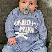 Brodie is registered to the contest to win money with this photo: baby, infant, pacifier, blue_outfit, sitting, couch, cozy, child, cute, indoor, clothing, face, person, young, small, sock, relaxed, home, portrait, casual