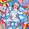 baby, baby_clothing, beach_ball, blanket, blue, child, circus, clouds, colorful, dumbo, elephant, hat, infant, lying_down, nursery, portrait, smiling, stars, stuffed_animal, toy