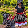 accessories, canine, dog, dress, fashion, gloves, greenery, happy, hat, leisure, matching_outfits, outdoor, park, pet, polka_dot, sidewalk, smile, stroller, summer, woman