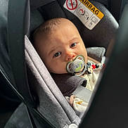 Tiago participe au concours pour gagner de l'argent avec cette photo : baby, car_seat, pacifier, child, infant, seatbelt, close_up, indoor, warning_label, cute, portrait, young_child, car_interior, person, baby_clothing, head, face, safety, seat, mickey_mouse