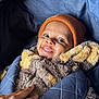 baby, child, smile, face, beanie, hat, jacket, fuzzy_clothing, hand, carrier, blue, orange, cozy, warm, infant, portrait, cute, happy, indoor, person