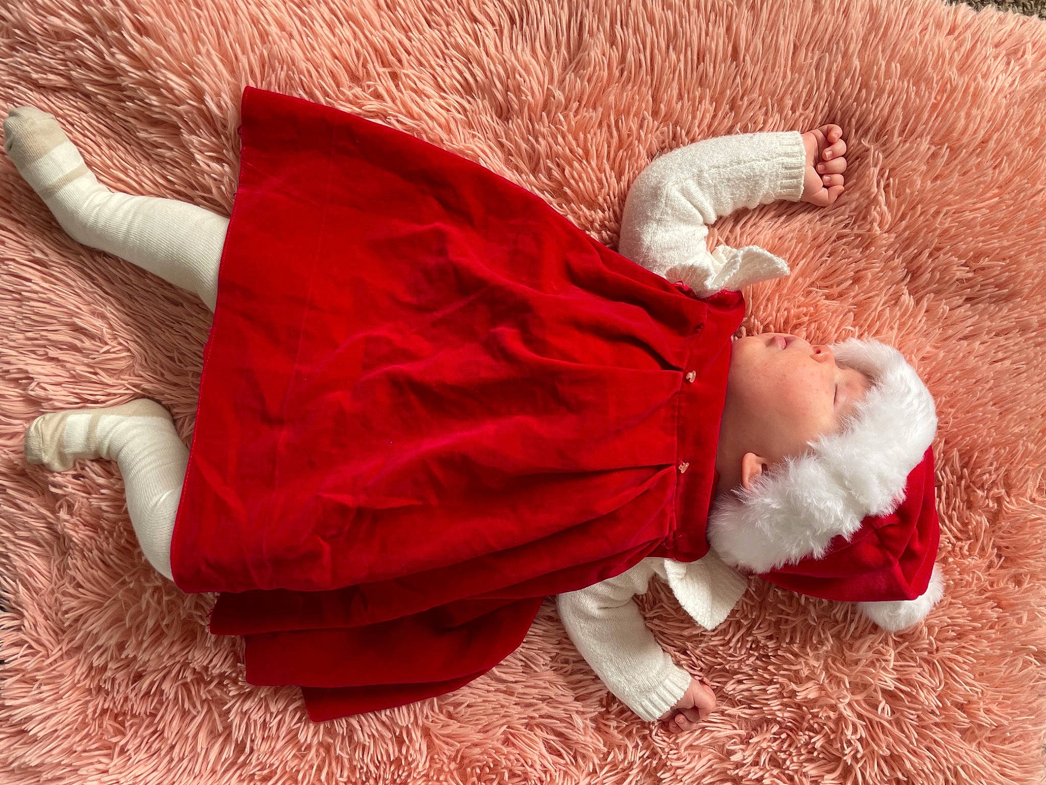 Dahlia is registered to the contest to win money with this photo: baby, baby_toddler_clothing, child, comfort, costume, costume_hat, fashion_accessory, flooring, foot, fur, grass, hat, human_body, human_leg, magenta, person, sitting, sleeve, toddler, wood