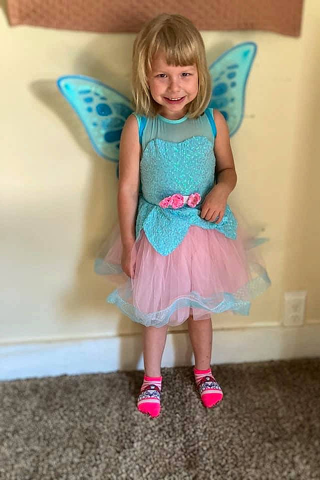 Rosemarie is registered to the contest to win money with this photo: baby_toddler_clothing, child, couch, day_dress, dress, event, eye, face, fun, hair, happy, head, joy, magenta, pattern, person, pink, purple, sleeve, smile