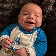 Aaron a rejoint le concours — aidez-le/la à gagner de superbes lots ! baby, smiling, blue_clothing, white_clothing, blanket, infant, happy, portrait, face, child, cute, hands, lying_down, soft_texture, cozy, indoor, young_child, apparel, expression, skin