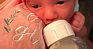 Mirabella joined the competition — help win amazing prizes! baby, infant, bottle, feeding, pink_bow, headband, blanket, embroidery, close_up, face, sleepy, cute, newborn, hand, soft_texture, milk, child, indoors, portrait, cozy