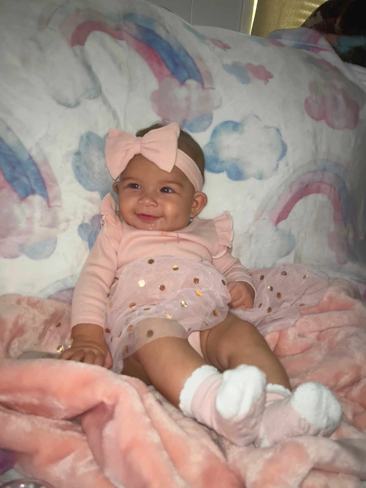 Alaiyah joined the competition — help win amazing prizes! baby, blanket, bow, child, clouds, cozy, cute, happy, headband, indoors, infant, pink_clothing, portrait, rainbow, seated, smiling, socks, soft_texture, tutu_skirt, warm