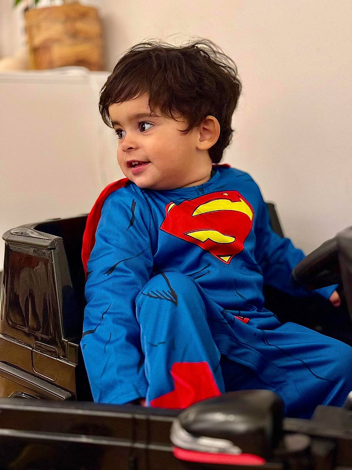Ilyan participe au concours pour gagner de l'argent avec cette photo : bag, baggage, box, chair, child, couch, electric_blue, fictional_character, fun, happy, justice_league, person, personal_protective_equipment, room, shipping_box, sitting, sleeve, superman, t_shirt, toddler