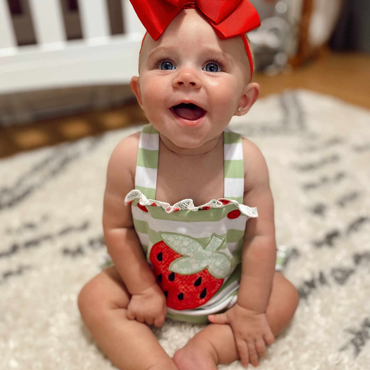 Wrenlee is registered to the contest to win money with this photo: accessories, baby, bodypart, clothing, couch, crib, dress, face, finger, furniture, hand, hardwood, head, indoors, infantbed, person, photography, portrait, sitting, wood