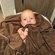 Oakley is registered to the contest to win money with this photo: baby, towel, blue_eyes, indoor, infant, blanket, skin, hand, face, child, wrapped, cute, soft, comfort, closeup, newborn, person, expression, warm, cozy