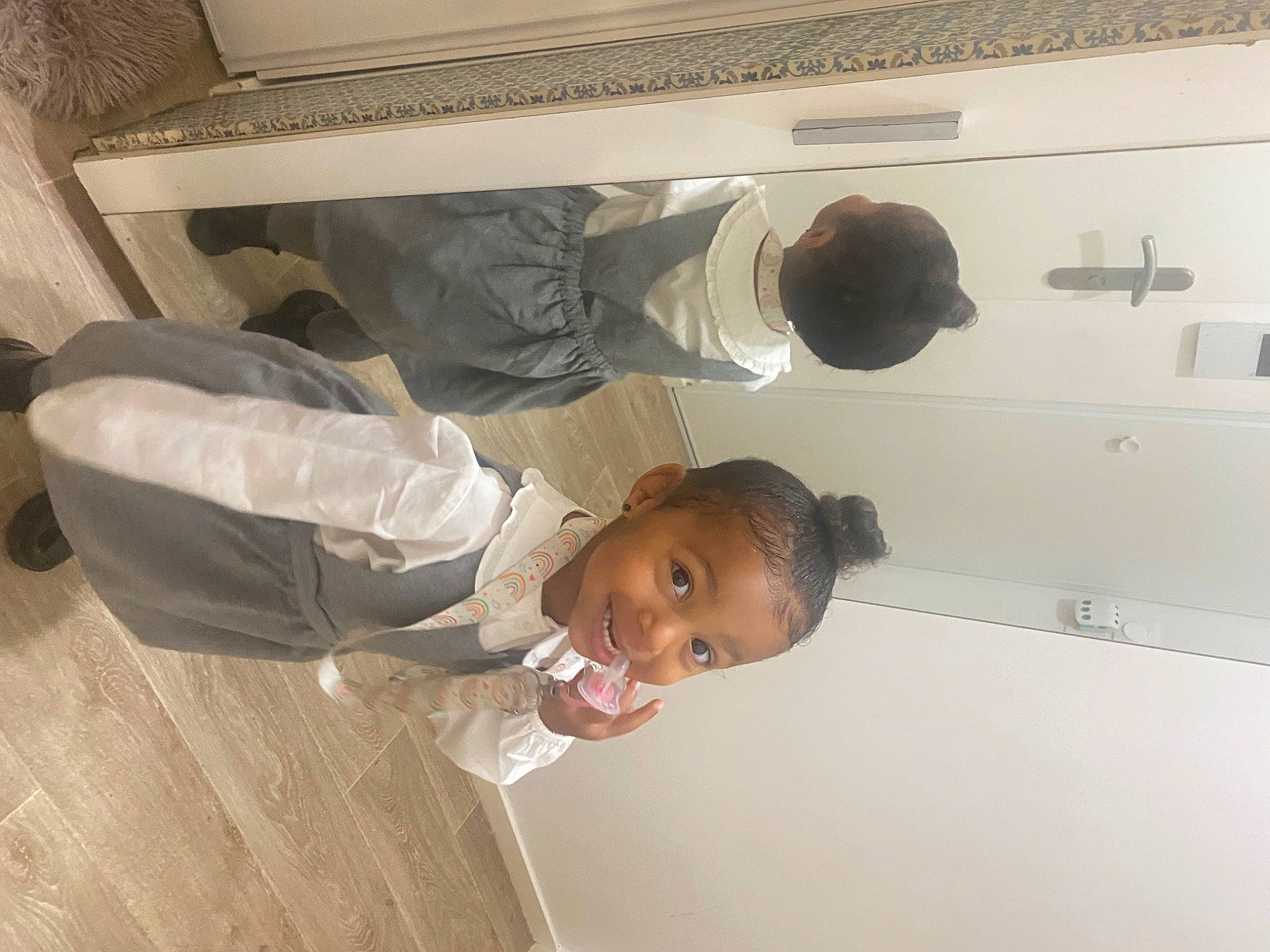 Shaya participe au concours pour gagner de l'argent avec cette photo : cabinetry, ceiling, child, comfort, door, elbow, flooring, gesture, hardwood, home_appliance, joy, major_appliance, person, refrigerator, room, smile, toddler, wood, wood_flooring