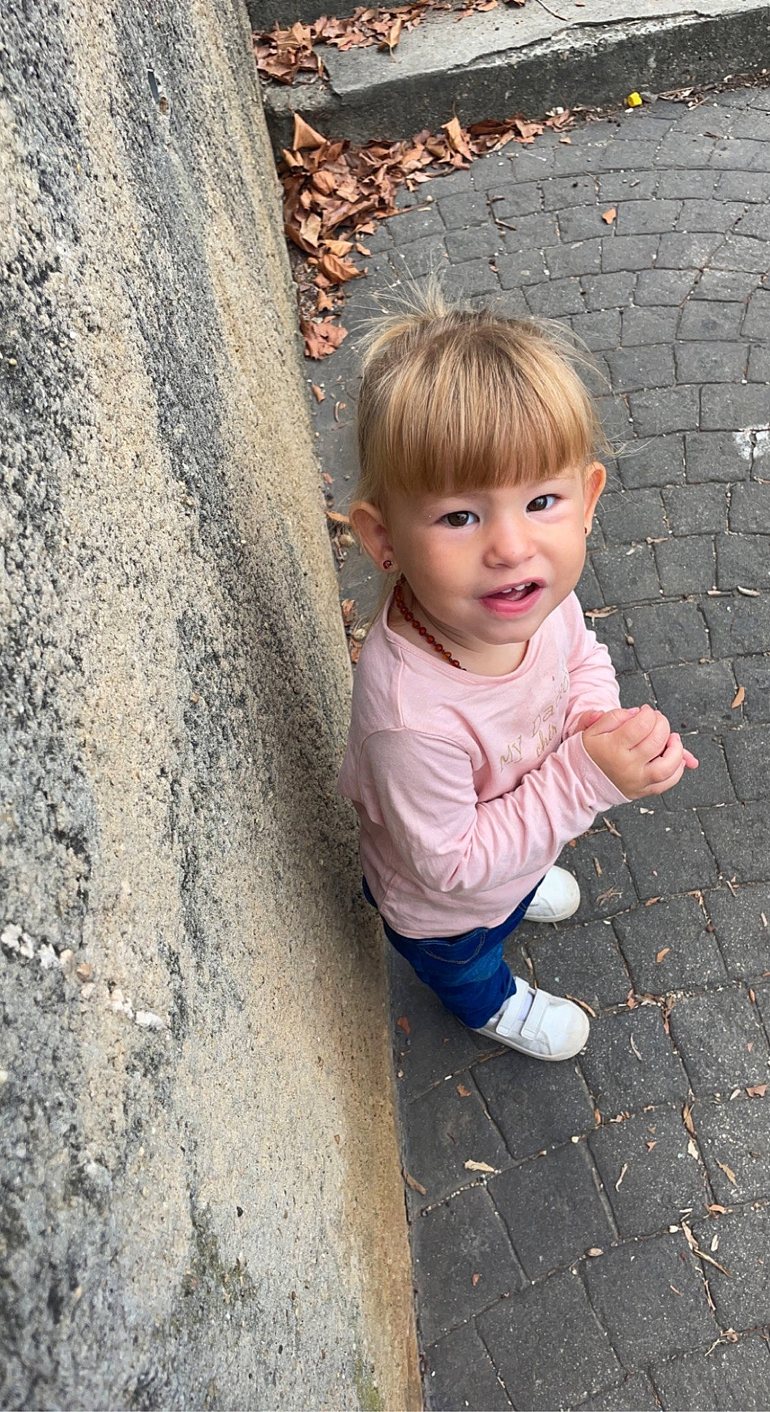 Athéna participe au concours pour gagner de l'argent avec cette photo : asphalt, baby_toddler_clothing, child, concrete, eye, face, flooring, fun, grass, hairstyle, happy, people_in_nature, person, road_surface, sitting, skin, smile, soil, toddler, trunk