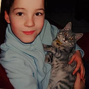 Cacahuète participe au concours pour gagner de l'argent avec cette photo : animal, cat, child, comfort, cozy, cute, eyes, face, feline, gray_tabby, hands, holding, hoodie, indoor, looking, pet, portrait, smiling, warm, young